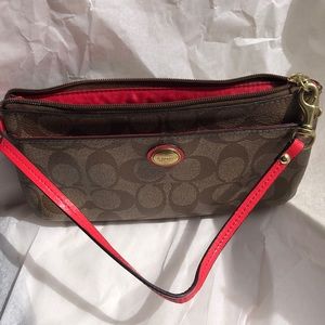 Peach colored Coach wrist bag